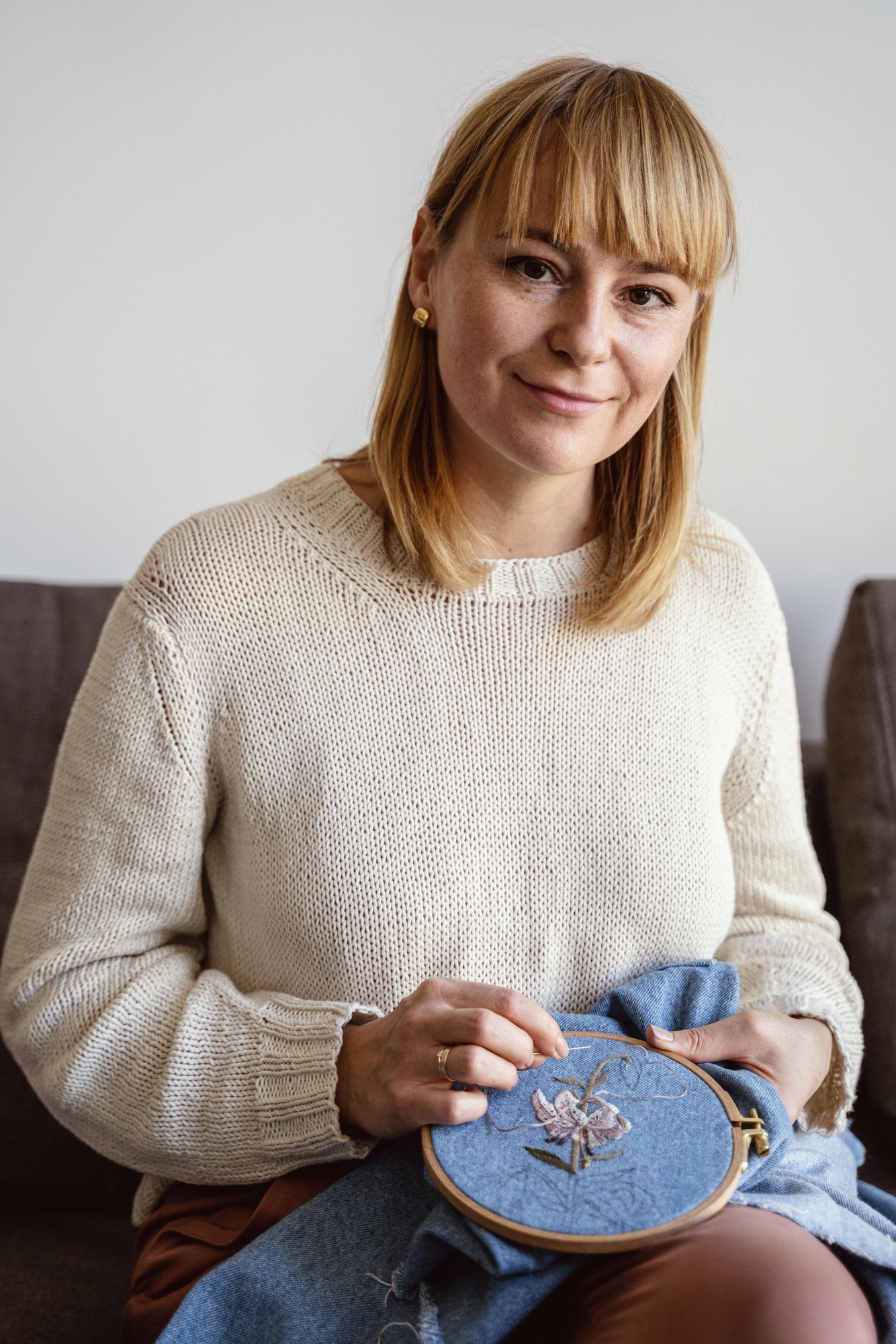 Portrait of lead embroiderer Anna with hoop